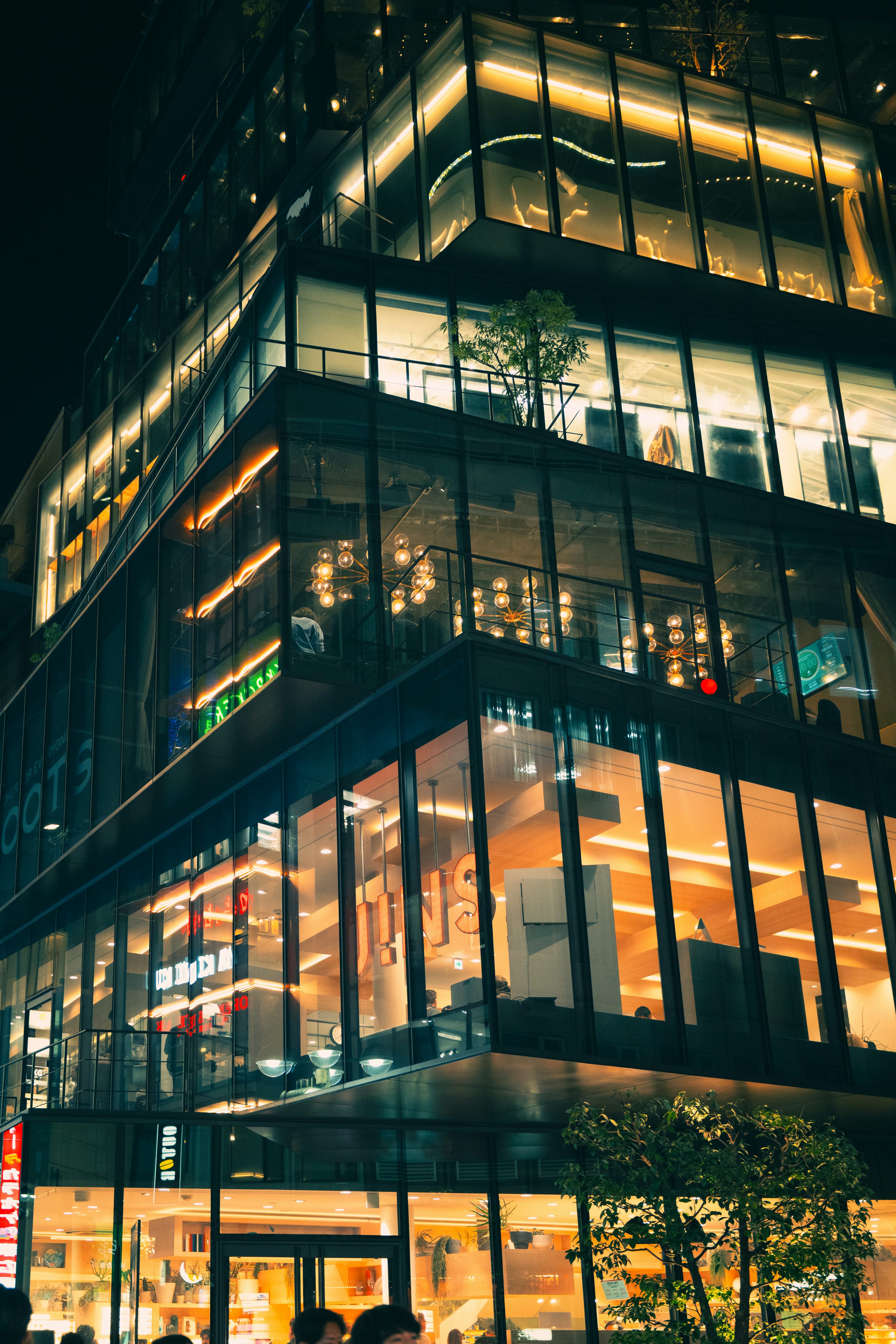 Modern glass office tower illuminated at night
